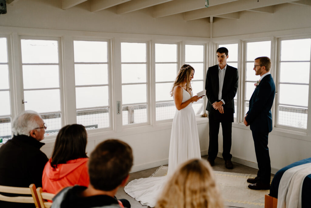 a bride and groom exchange vows as their family watch in a fire lookout during their Washington elopement