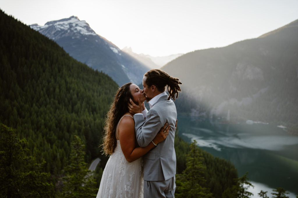 A bride and groom have their first kiss above Diablo Lake in the north cascades