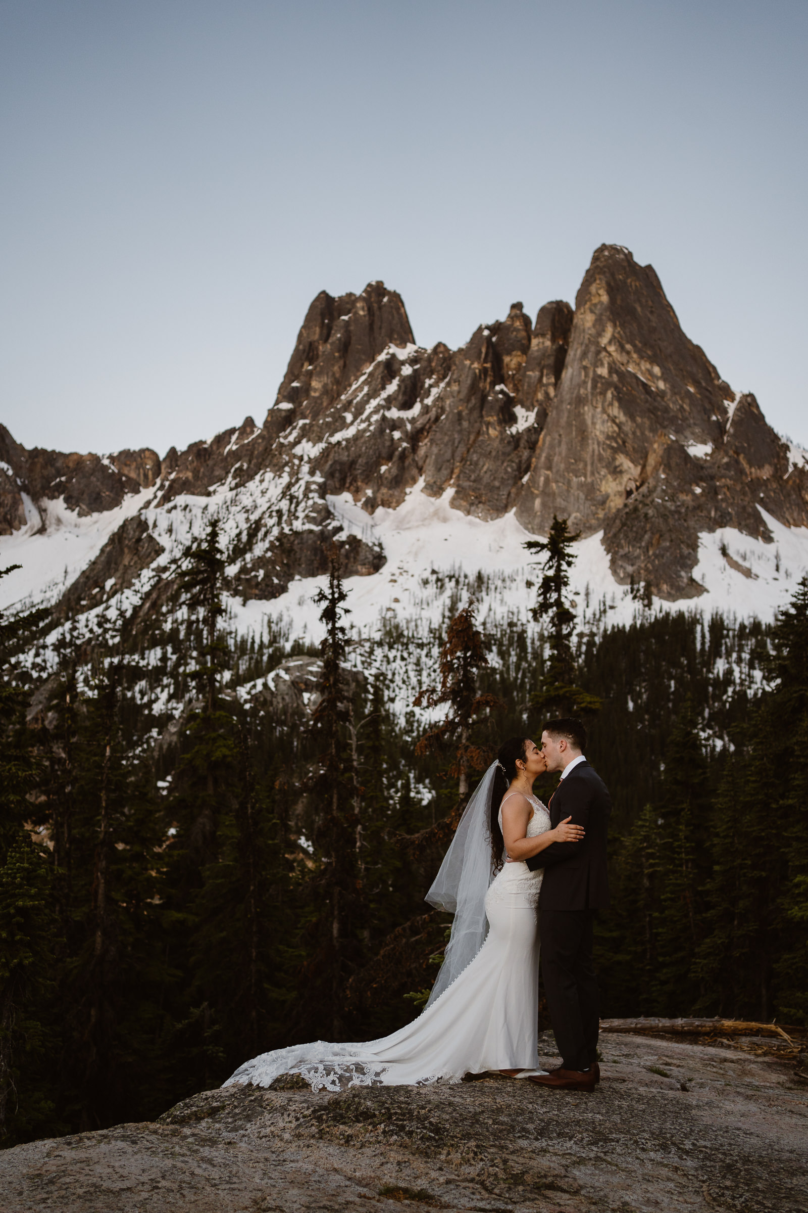 a bride and groom have their first kiss in front of liberty bell rock during their north cascades elopement