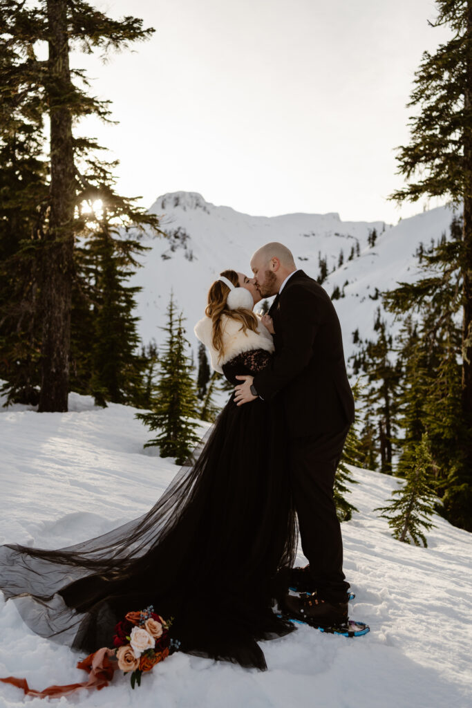 a bride and groom have their first kiss at sunset during their north cascades snowshoeing elopement
