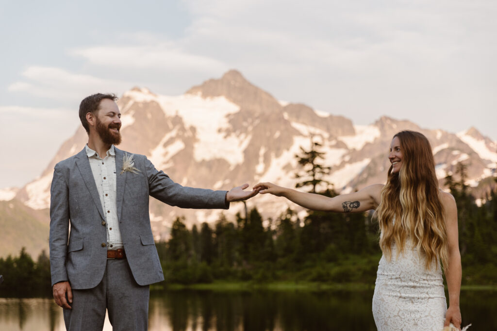 a bride and groom hold hands in front of mount shuksan during their north cascades elopement