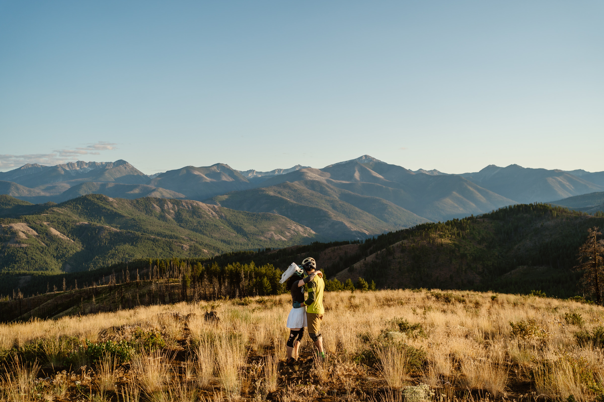 a bride and groom in bike attire embrace during their north cascades mountain biking elopement