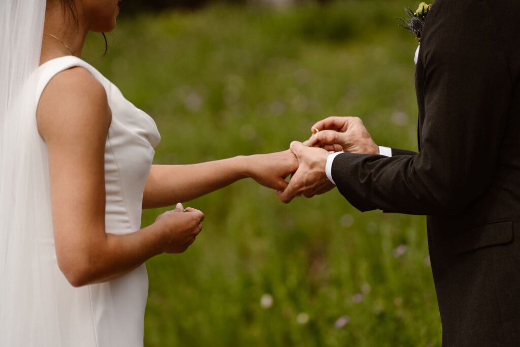a bride and groom exchange rings during a mt rainier elopement ceremony