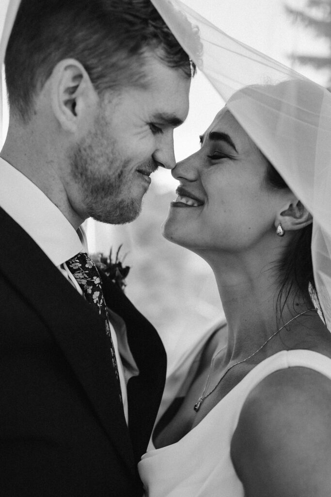black & white photo of a bride and groom underneath a veil during their mount rainier micro wedding