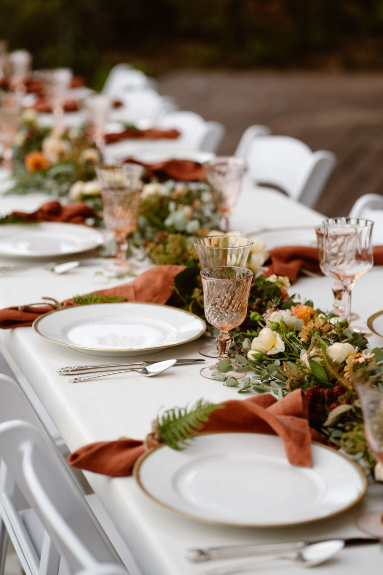 a beautiful tablescape with plates, silverware, napkins, goblets, and florals for a mount rainier micro wedding reception dinner