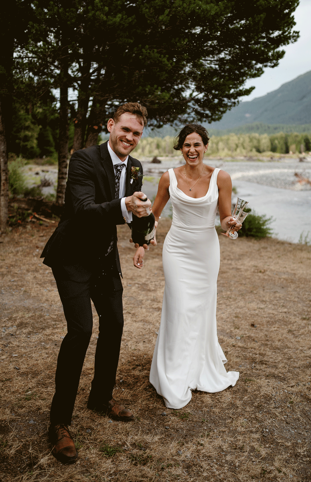 a groom sprays champagne while the bride laughs during their mt rainier micro wedding