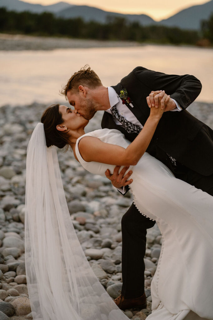 a groom dips a bride for a kiss