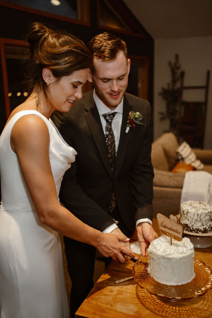 a bride and groom cut their cake during their mount rainier micro wedding reception