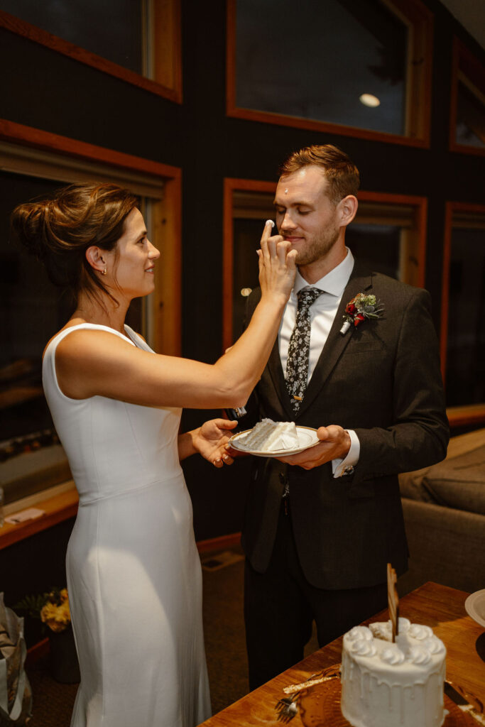 a bride sneaks some cake onto her groom's nose
